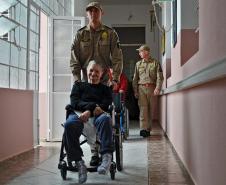 Moradoras e funcionários de asilo em Curitiba (PR) participam de simulação de evacuação com o Corpo de Bombeiros.