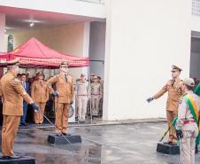Ato de passagem de comando, comandantes substituto e substituído perfilam espadas à frente da Bandeira Nacional.