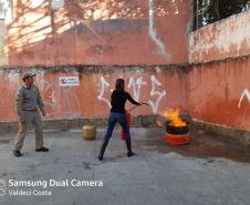 Instrução prática de Combate à Incêndios, brigadista executando o combate à incêndio com extintor de pó químico seco.