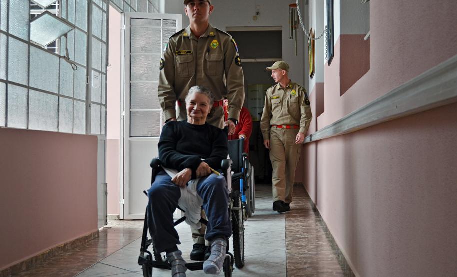 Moradoras e funcionários de asilo em Curitiba (PR) participam de simulação de evacuação com o Corpo de Bombeiros.