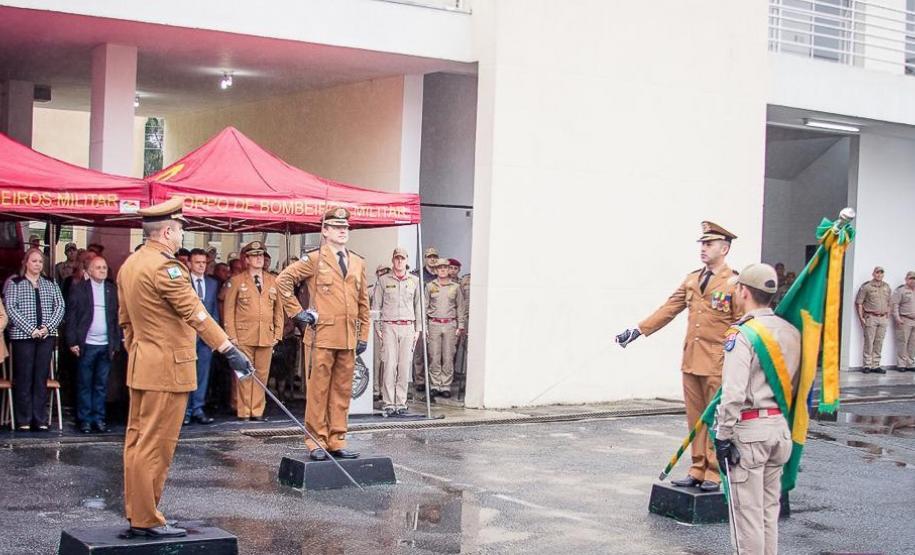 Ato de passagem de comando, comandantes substituto e substituído perfilam espadas à frente da Bandeira Nacional.